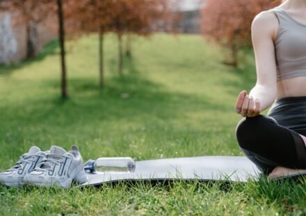 A person meditating outdoors, sitting still with quiet determination