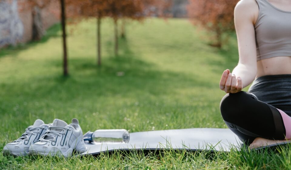 A person meditating outdoors, sitting still with quiet determination
